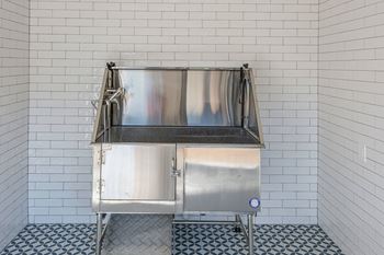 A stainless steel sink in a tiled bathroom.